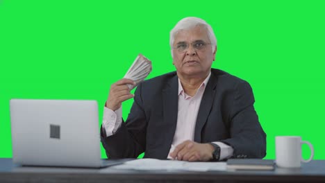 Confident-Indian-senior-businessman-using-money-as-fan-Green-screen