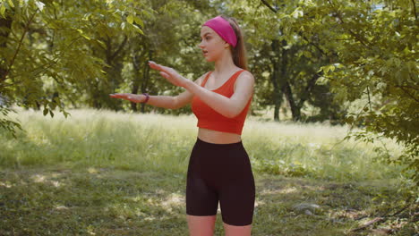 Sporty-young-woman-athlete-doing-working-out-stretching-fitness-exercises-outdoors-in-summer-park