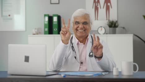 Happy-Indian-senior-doctor-showing-victory-sign