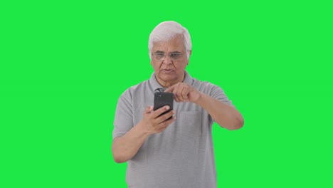 Indian-old-man-scrolling-through-phone-Green-screen