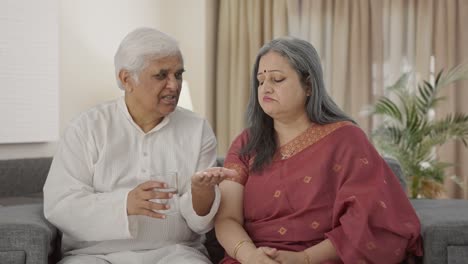 Caring-Old-Indian-man-giving-medicine-to-his-sick-wife