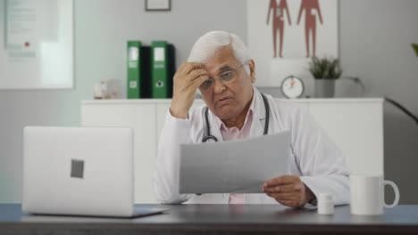 Tensed-Indian-senior-doctor-discussing-reports-with-the-patient