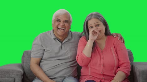 Happy-Indian-old-couple-laughing-while-watching-TV-Green-screen