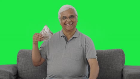 Happy-Indian-old-man-using-money-as-fan-Green-screen