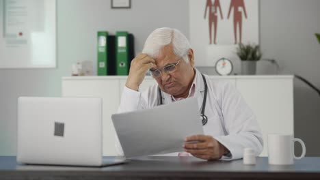 Confused-Indian-senior-doctor-reading-health-reports