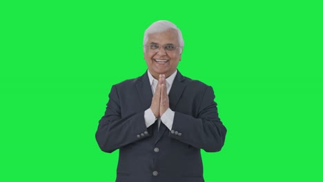 Happy-Indian-senior-journalist-doing-Namaste-and-greeting-Green-screen