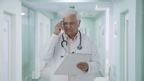 Confused-Indian-senior-doctor-writing-prescription