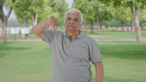 Angry-Indian-old-man-showing-thumbs-down-in-park