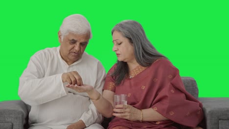 Fürsorgliche-Alte-Indische-Frau-Gibt-Ihrem-Kranken-Mann-Medizin,-Greenscreen