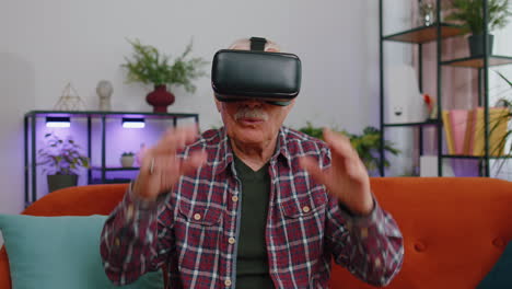 Hombre-Mayor-Usando-La-Aplicación-De-Casco-VR-Para-Jugar-Juegos-De-Simulación-Viendo-Videos-De-Realidad-Virtual-En-Casa