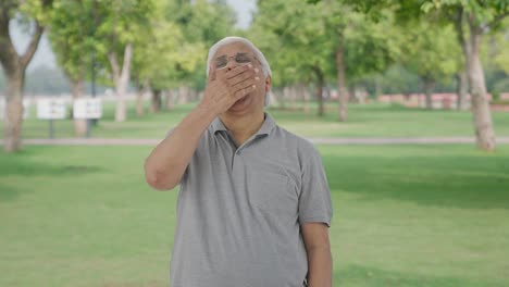 Sleepy-and-tired-Indian-old-man-yawning-in-park