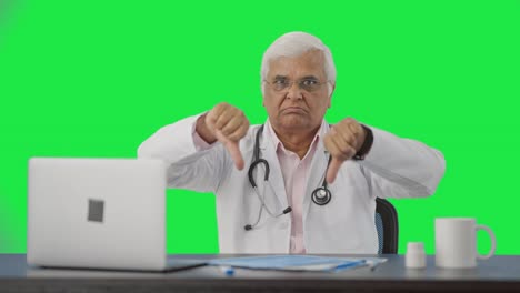 Angry-Indian-senior-doctor-showing-thumbs-down-Green-screen