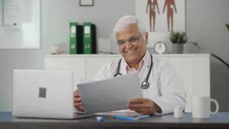 Happy-Indian-senior-doctor-reading-health-reports