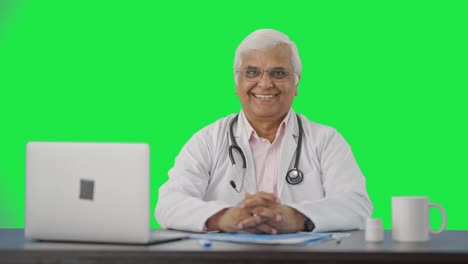 Happy-Indian-senior-doctor-putting-stethoscope-on-shoulders-Green-screen