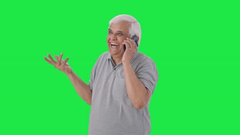 Happy-Indian-old-man-talking-on-call-Green-screen