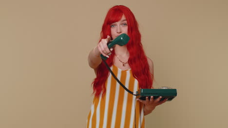 Cheerful-red-hair-girl-secretary-talking-on-wired-vintage-telephone-of-80s,-say-hey-you-call-me-back