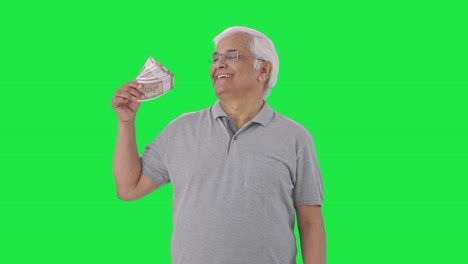 Happy-Indian-old-man-using-money-as-fan-Green-screen