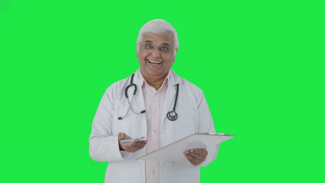 Happy-Indian-senior-doctor-talking-to-the-patient-Green-screen