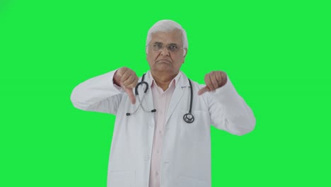 Médico-Senior-Indio-Enojado-Mostrando-Los-Pulgares-Hacia-Abajo-En-La-Pantalla-Verde