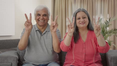 Happy-Indian-old-couple-showing-victory-sign