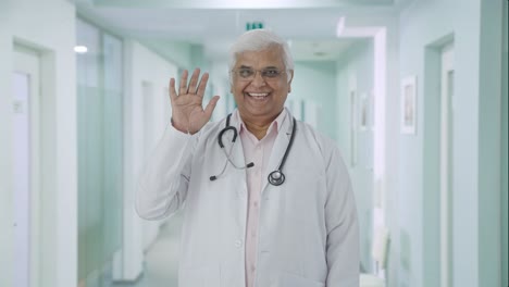 Happy-Indian-senior-doctor-saying-Hello-and-waving