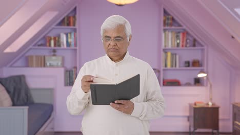 Confused-Indian-old-man-reading-a-book