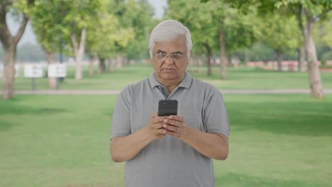 Angry-Indian-old-man-chatting-with-someone-in-park