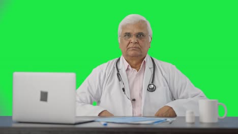 Indian-senior-doctor-staring-at-the-camera-Green-screen