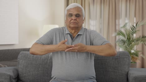 Relaxed-Indian-old-man-doing-breathe-in-breathe-out-exercise