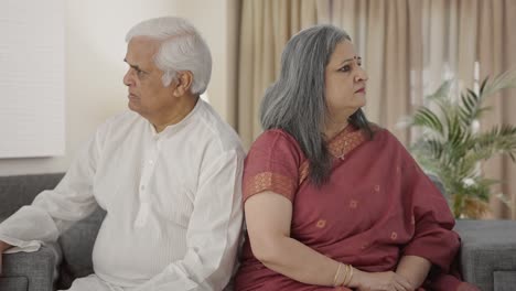 Angry-Old-Indian-couple-sitting-back-to-back