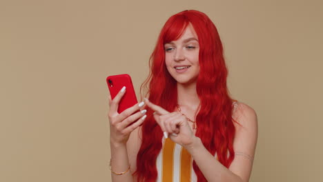 Redhead-girl-using-mobile-phone-typing-post-on-web-sms-message-browsing-addiction-of-social-networks