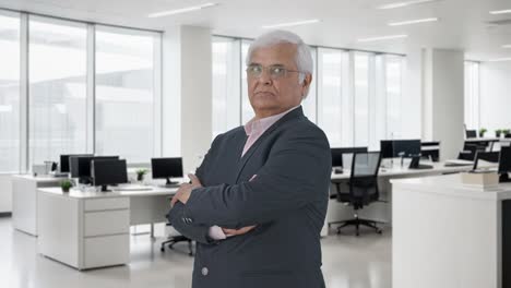 Portrait-of-Indian-senior-businessman-standing-crossed-hands