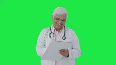 Feliz-Médico-Senior-Indio-Escribiendo-Receta-En-Pantalla-Verde