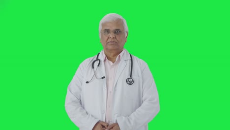 Serious-Indian-senior-doctor-looking-at-the-camera-Green-screen