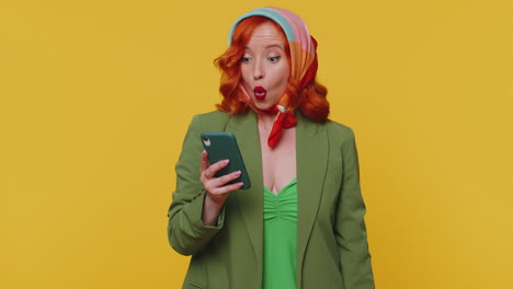 Happy-redhead-woman-looking-smartphone-display-sincerely-rejoicing-win,-receiving-money-dollar-cash