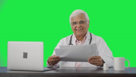 Happy-Indian-senior-doctor-discussing-reports-with-the-patient-Green-screen