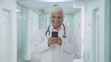 Happy-Indian-senior-doctor-chatting-with-someone