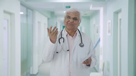 Feliz-Médico-Senior-Indio-Explicando-Informes-De-Salud-Al-Paciente