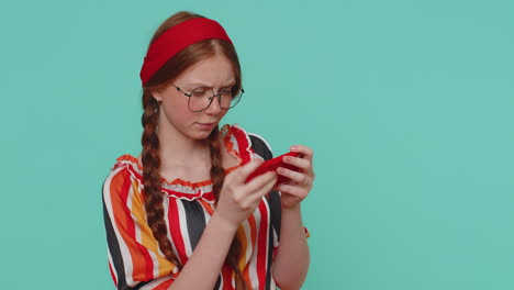 Worried-funny-addicted-redhead-girl-enthusiastically-playing-drive-racing-video-game-on-mobile-phone