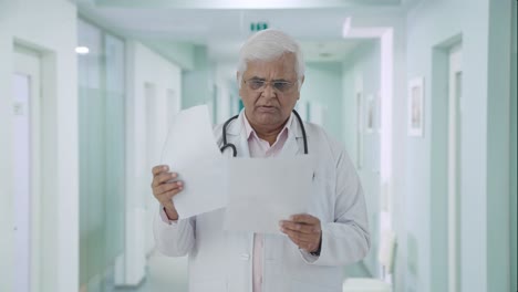 Indian-senior-doctor-reading-reports