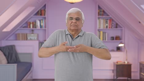 Indian-old-man-doing-breathe-in-breathe-out-exercise