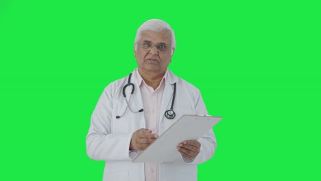 Médico-Senior-Indio-Hablando-Con-La-Pantalla-Verde-Del-Paciente