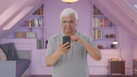 Sleepy-Indian-old-man-scrolling-through-phone