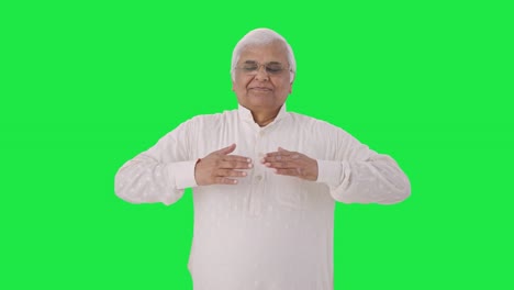 Relaxed-Indian-old-man-doing-breathe-in-breathe-out-exercise-Green-screen