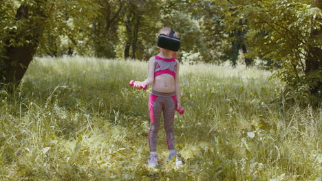 Niño-Atlético-Con-Casco-Vr-Haciendo-Ejercicios-De-Fitness-Con-Pesas-Al-Aire-Libre-En-El-Parque