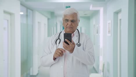 Indian-senior-doctor-scrolling-through-phone