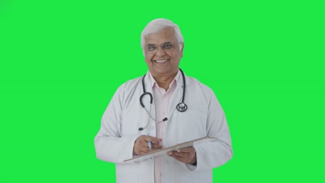 Happy-Indian-senior-doctor-listening-to-the-patient-Green-screen