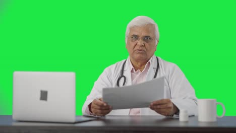 Sad-Indian-senior-doctor-discussing-reports-with-the-patient-Green-screen