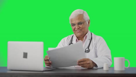 Feliz-Médico-Senior-Indio-Revisando-Informes-De-Salud-Pantalla-Verde