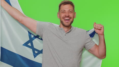 Young-man-in-gray-t-shirt-waving-and-wrapping-in-Israel-national-flag,-celebrating-Independence-day